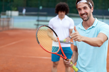 Group of healthy happy friends at the club playing tennis