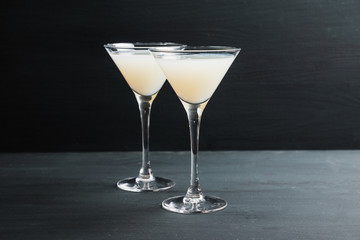 Sweet coconut cocktail in martini glass on the wooden background. Selective focus. Shallow depth of field. 