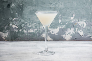 Sweet coconut cocktail in martini glass on the wooden background. Selective focus. Shallow depth of field. 