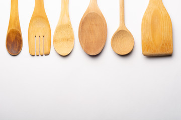Vintage Wooden Spoons, Fork and Stirrer on White Textured Paper. Kitchen and Cooking Concept.