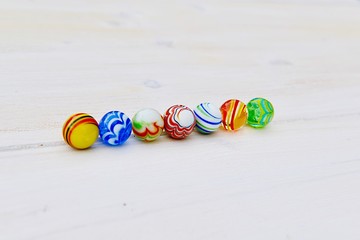 marbles on white wooden background
