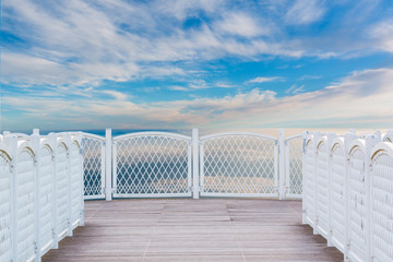 White balcony with perspective wood floor on sky background.