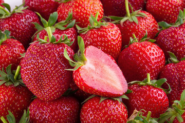 Vivid colorful red strawberries over the strawberries background.