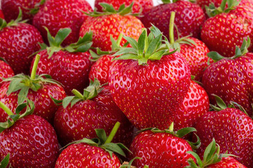 Vivid colorful red strawberries over the strawberries background.