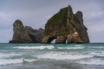 Fototapeta premium Rippled Sand and rock formations at Wharariki Beach, Nelson, North Island, New Zealand, Archway Islands, Natural wallpaper background, landscape photography, amazing stone formation
