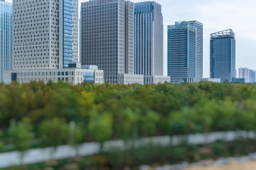 Fototapeta premium green trees front of modern glass office building