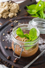 Vegan chocolate mousse with halvah and fresh mint in a jar.