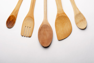 Vintage Wooden Spoons, Fork and Stirrer on White Textured Paper. Kitchen and Cooking Concept.