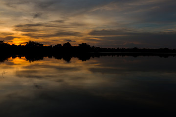 Silhouette of a trees at the lake in sunset with beautiful reflection.