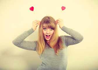 Cheerful girl fooling with hearts.