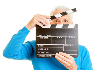 Mann als Regisseur schaut durch Filmklappe - obrazy, fototapety, plakaty