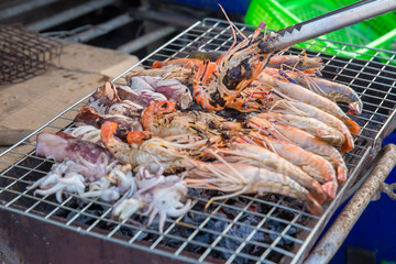 Professional Chef Cooking  Prawns or shrimp grilled on charcoal stove. shrimp grilled bbq seafood on stove.Closed up river prawn charcoal grilled on stove with Thai style homemade.