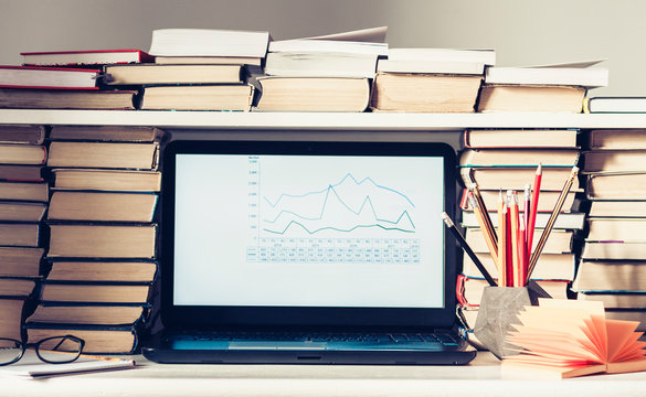 Laptop, Stack Of Books, Notebooks And Pencils On White Table, Education Office Concept Background.