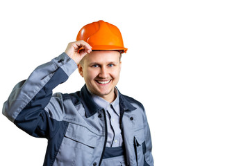 Portrait of a young builder worker in an orange helmet. He welcomes you to the camera. Repair and construction. isolated. Close-up