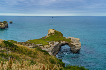 photography of tunnel beach in New Zealand, DUNEDIN, NEW ZEALAND Tunnel beach, Dunedin, South island of New Zealand, amazing coast line from above with a drone, Cliff formations at Tunnel Beach