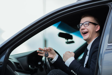 cheerful businessman showing keys to his new car