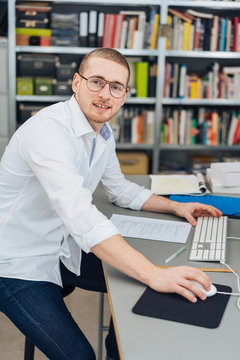 Young man in glasses working at computer
