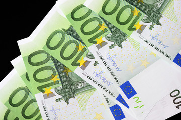 One Hundred euro banknotes on a dark background close up