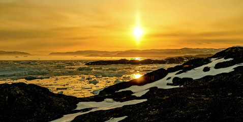 Golden hour winter and glacier ice fjord landscapes near Ilulissat in Greenland during midnight sun. © Christopher