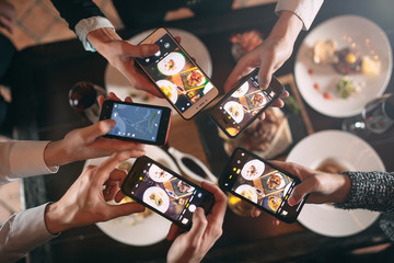 Group of friends going out and taking a photo of food together with mobile phone - Powered by Adobe