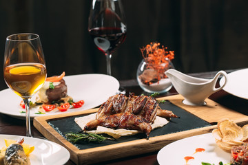 Grilled partridge, sea bass, Tartarus.  Different dishes on the table in the restaurant.