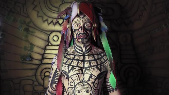 Tribal shaman with black paint on his body and blood around his mouth