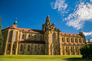 Kladruby, Czech Republic / Europe - July 7 2018: Church of the Assumption of the Virgin Mary built in baroque gothic style, yellow historical building, sunny day, green grass, blue sky with clouds