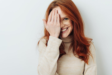 Smiling attractive woman covering one eye