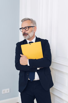 Mature businessman in glasses holding folder