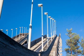 Abandoned wooden ski jumping hill on blue sky background in Kouvola, Finland