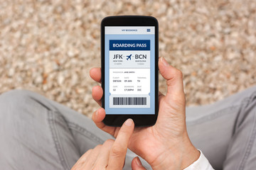 Hands holding smart phone with boarding pass concept on screen