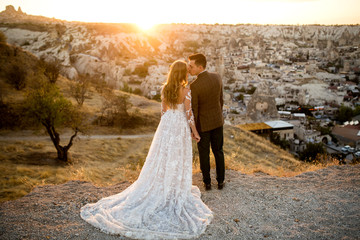 Beautiful wedding couple posing on peak near Cappadocia