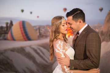 Beautiful wedding couple posing in nature near balloons