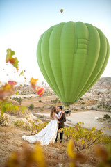 Beautiful wedding couple posing in nature near balloons