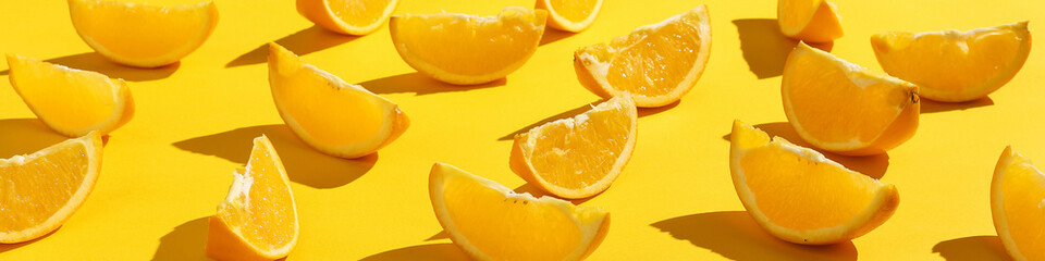 Naklejka na ściany i meble Oranges slices on a yellow background, bright pattern wallpaper.