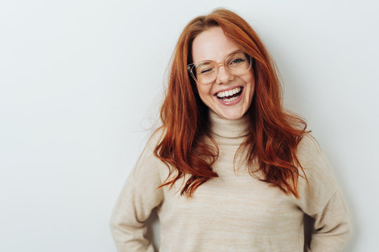 Laughing red-haired girl in glasses portrait