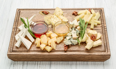 Assortment of various types of cheese on wooden board