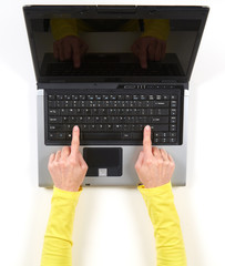 Hands in yellow jacket and black laptop