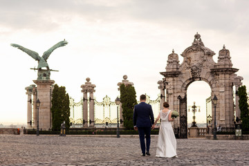 Obraz premium Beautiful romantic wedding couple of newlyweds hugging near old castle