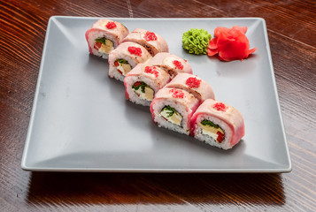 Salmon, tuna, sushi rolls set. On wooden background