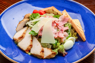 Chicken Caesar Salad. Caesar Salad with grilled chicken on plate. Grilled chicken breasts and fresh salad in plate