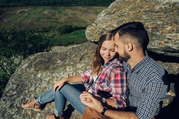 Young couple in love outdoor.  Travelers couple look at the mountain.