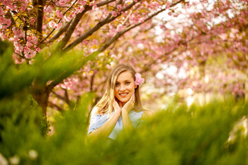 Fototapeta na wymiar Outdoor fashion photo of young beautiful lady surrounded spring leaves