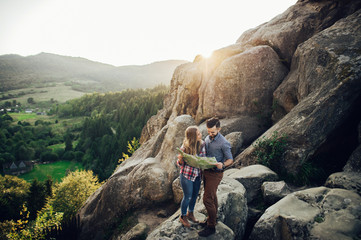 Young couple in love outdoor.  Travelers couple look at the mountain.