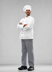 cooking, profession and people concept - happy male indian chef in toque over grey background