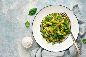 Fusilli pasta with basil pesto. Top view with copy space.