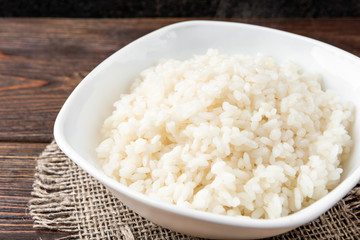 Rice porridge on dark wooden background.
