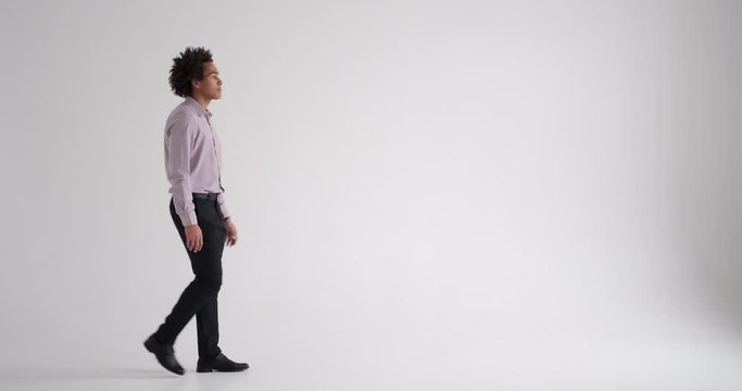 Handsome African american businessman walking and standing with arms crossed in studio