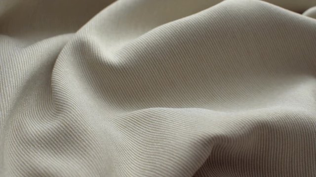 The texture of the fabric. Beige fabric pleated. Close-up. Can be used as a background. HD 
