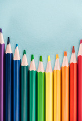 top view of rainbow multicolored pencils on blue background, lgbt concept